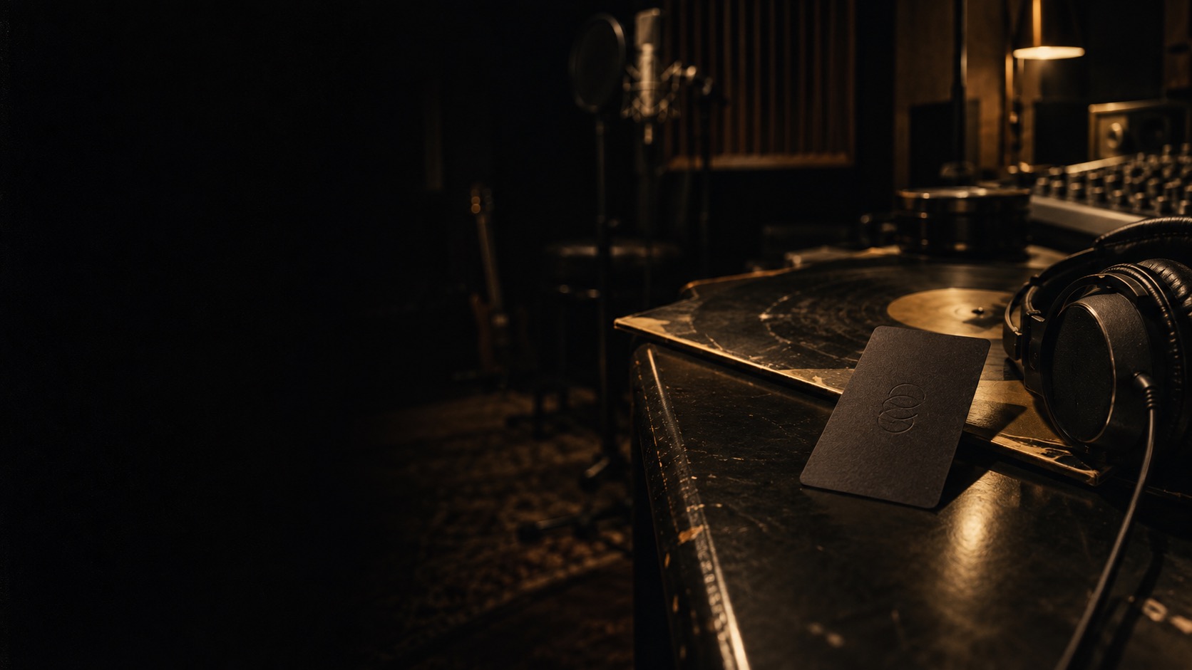 A studio turntable in low light with a black membership card resting on a vinyl record